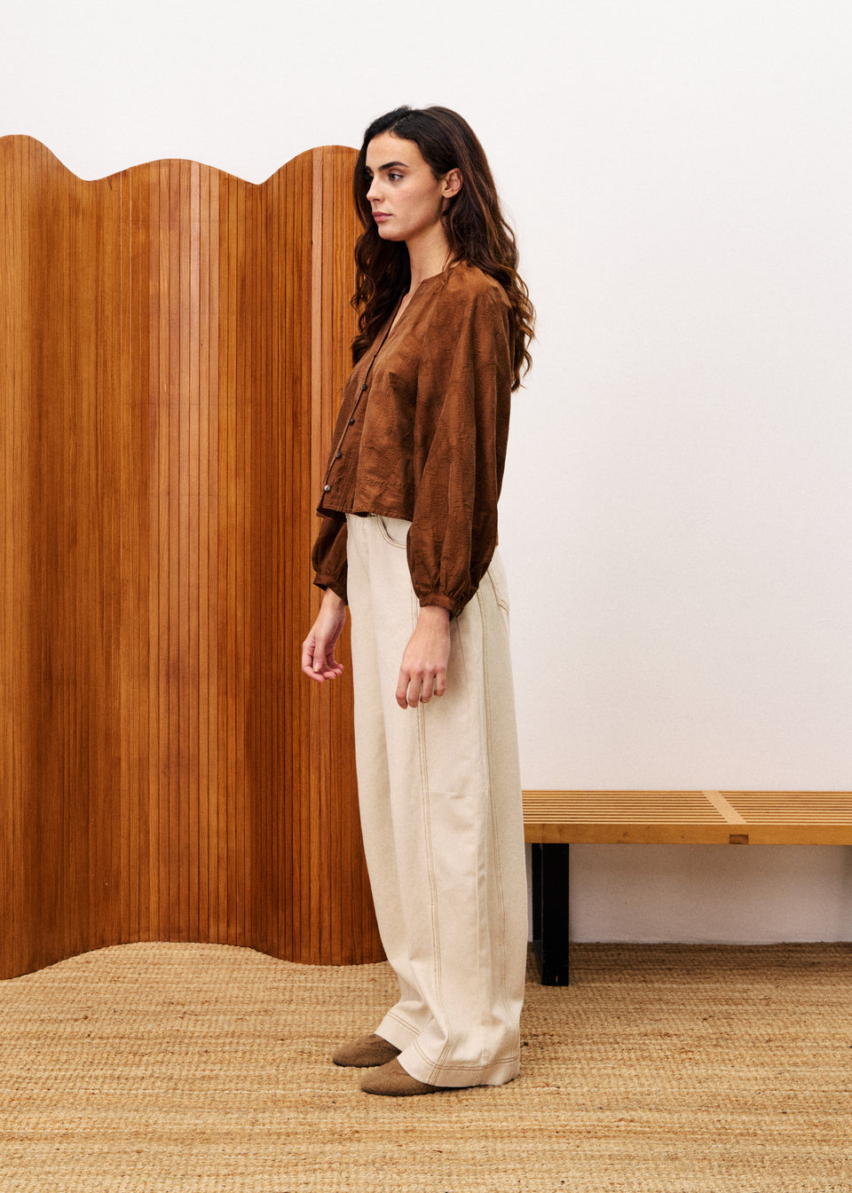 Textured Pensee blouse in neutral tone with long puff sleeves, V-neckline, and loose flowing fit made from Lyocell blend.