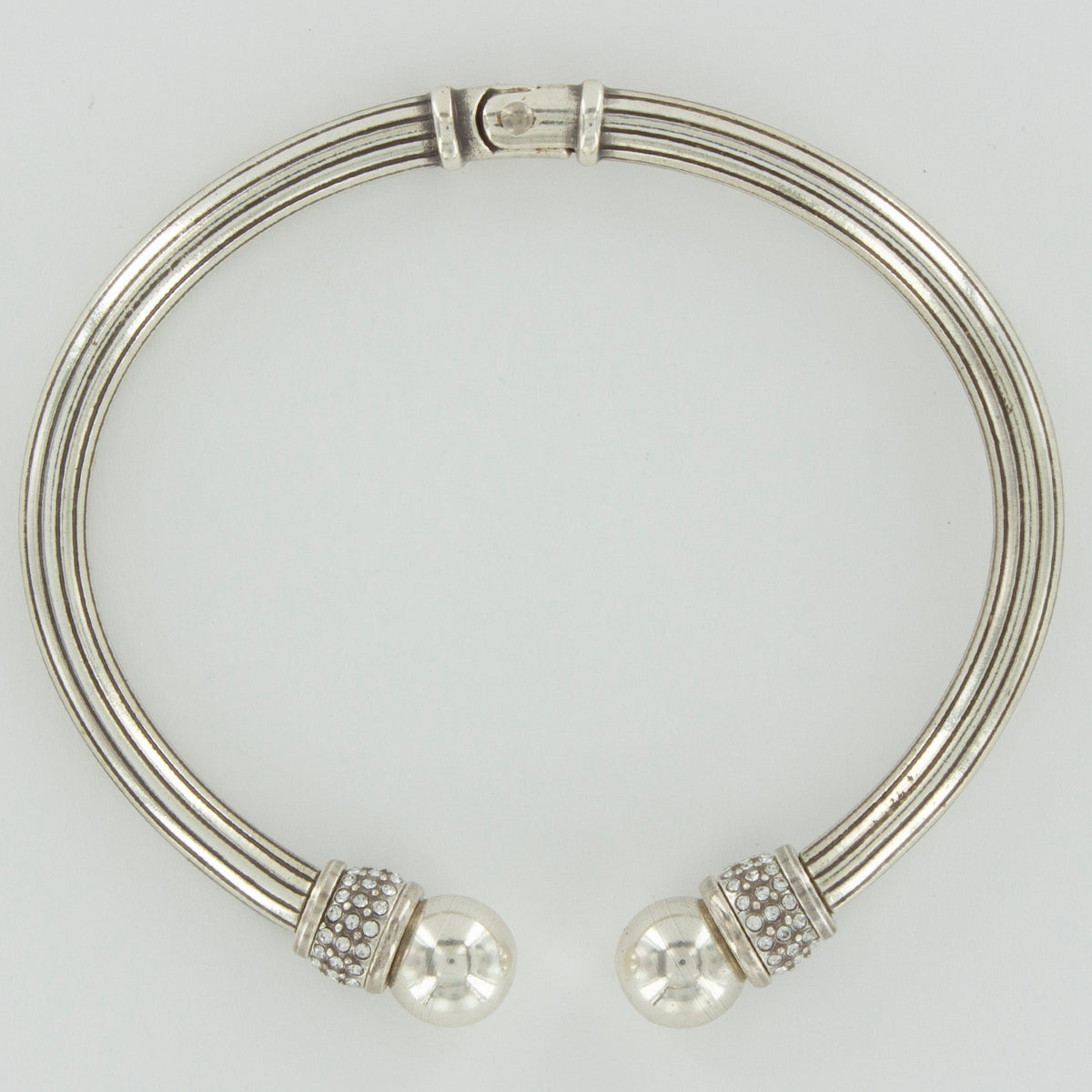 Meridian silver-plated open hinged bangle with ribbed band and crystal-studded ball ends.