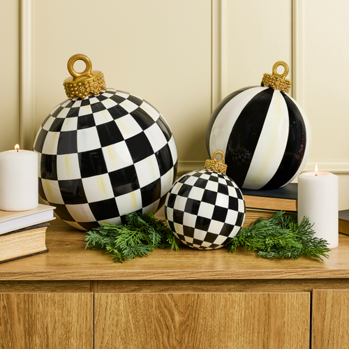 Black and white striped medium tabletop ornament with a gold top on a wooden surface.