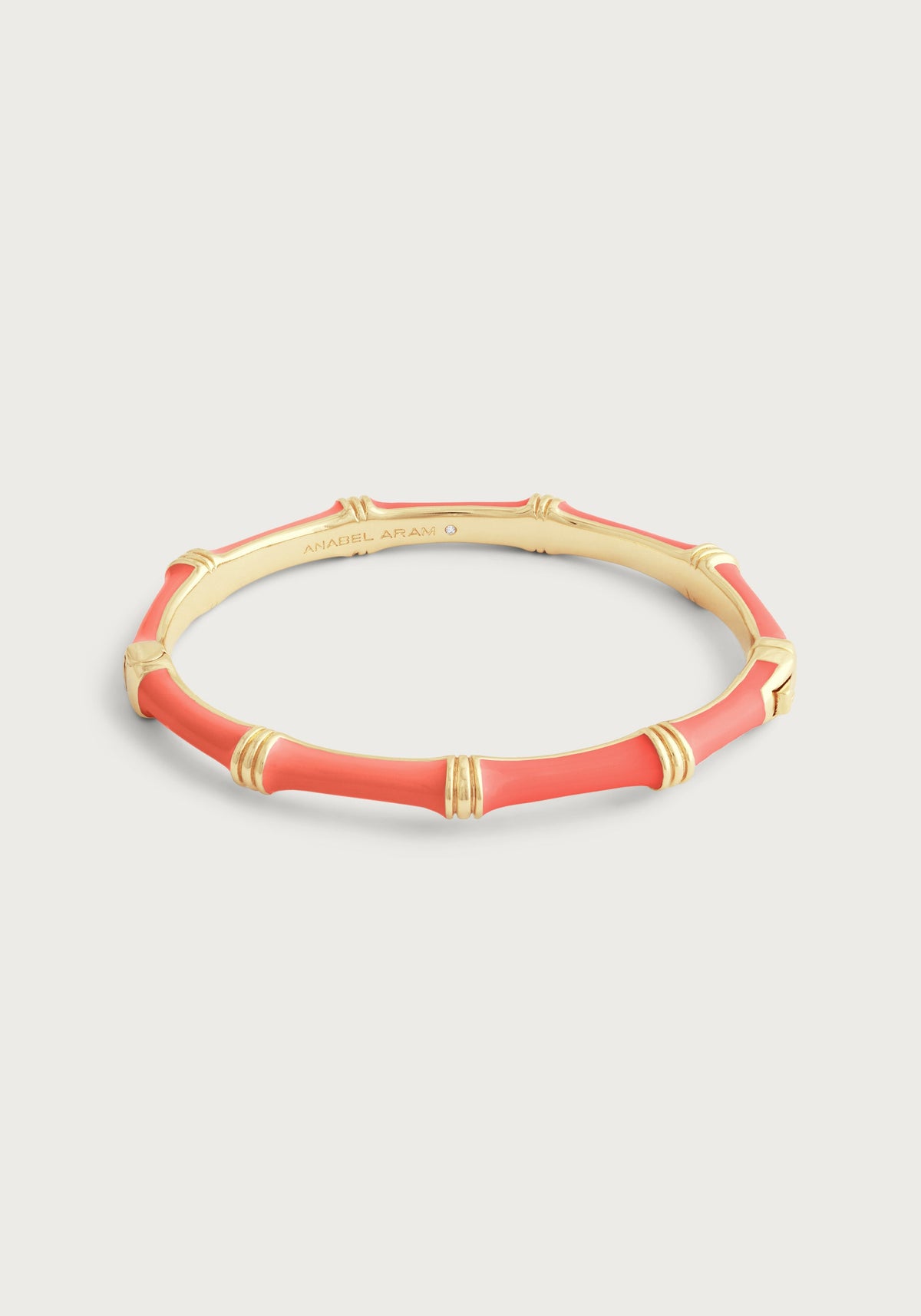 Coral hand-painted enamel and 18K gold-plated bamboo-shaped hinged bangle with a crystal accent.