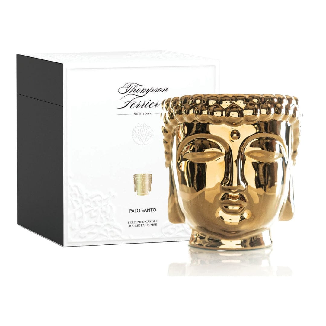 Gold Buddha candle in a cylindrical container with intricate relief detailing.