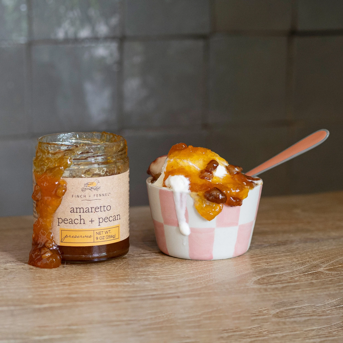 9oz jar of Amaretto Peach Pecan Preserves with peach fruit pieces and pecans visible.