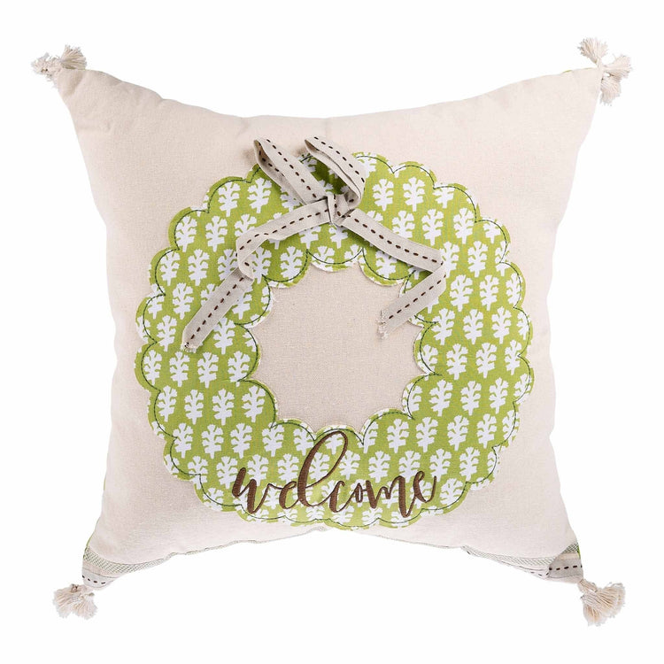 Square green pillow featuring a white wreath with leaves.