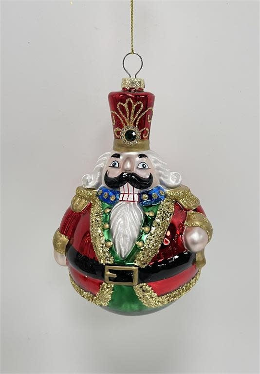Glass nutcracker ornament with a classic soldier silhouette in red and gold tones.