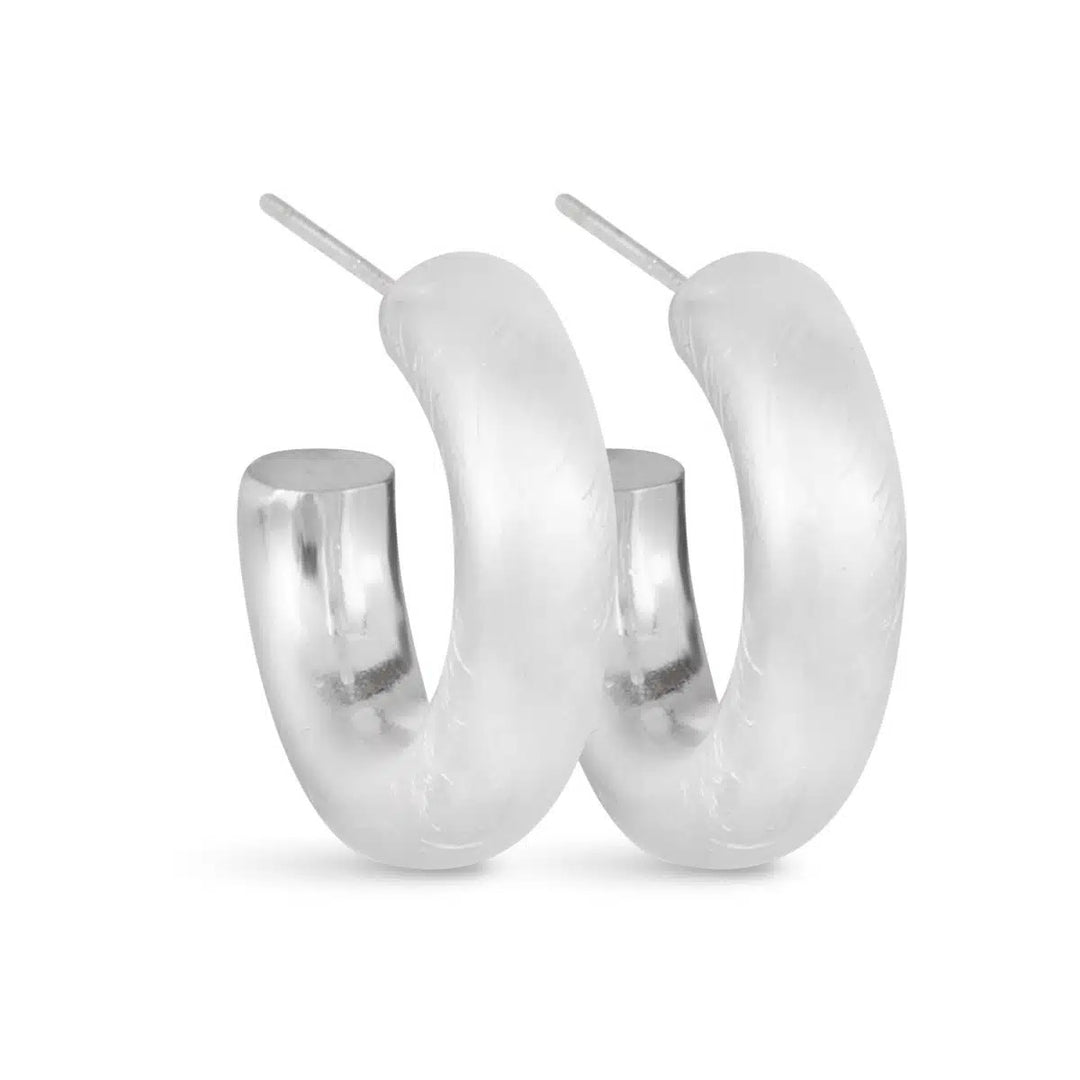 Pair of Olivia matte silver huggie hoop earrings with a thick, rounded design.