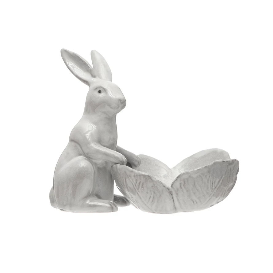 Stoneware rabbit figurine holding a flower-shaped bowl in neutral tones.