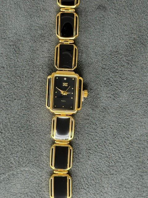 Sleek ladies watch with a rectangular black dial and gold-toned link bracelet with black inlays.
