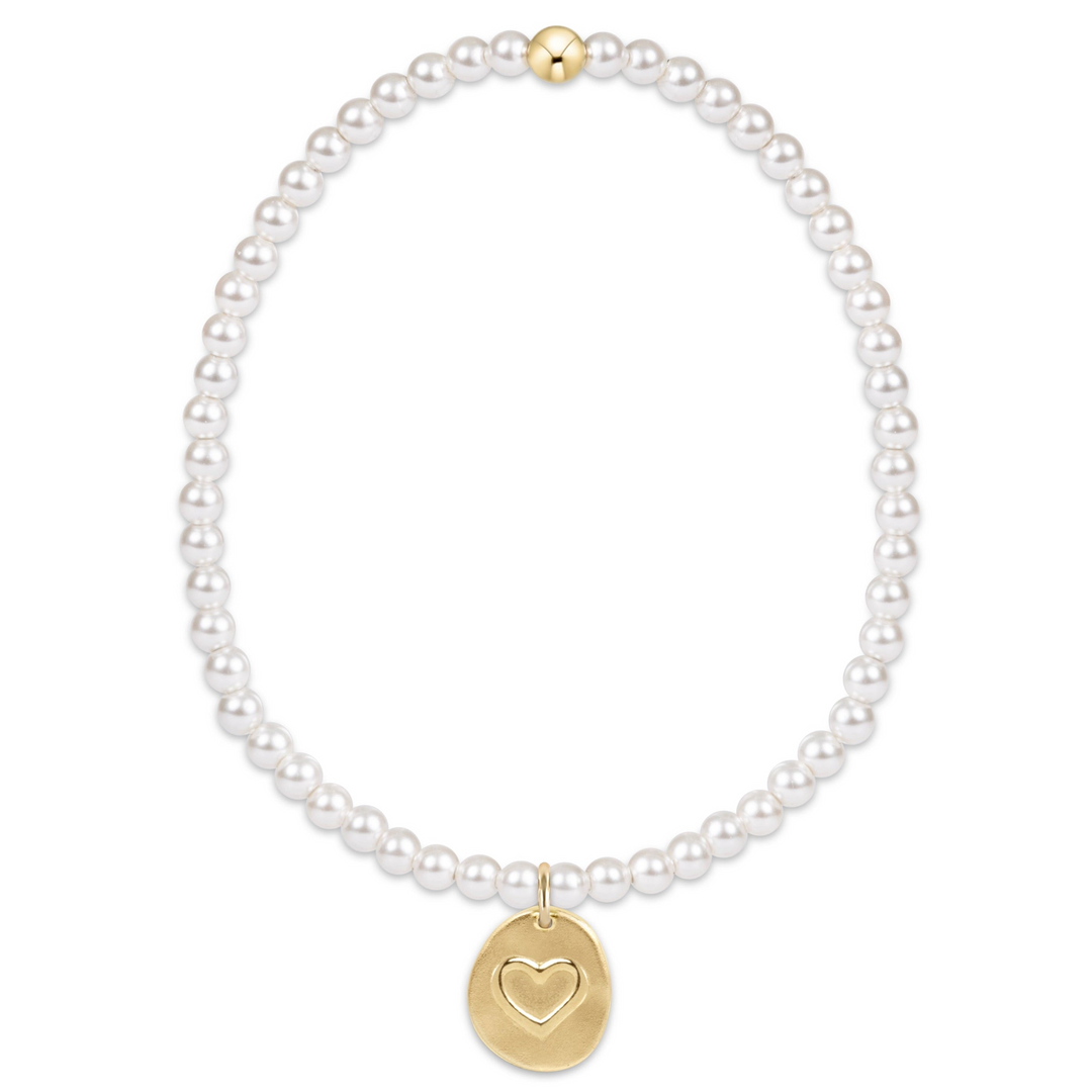 Classic 3mm pearl bracelet with a small gold disc charm featuring an engraved heart.