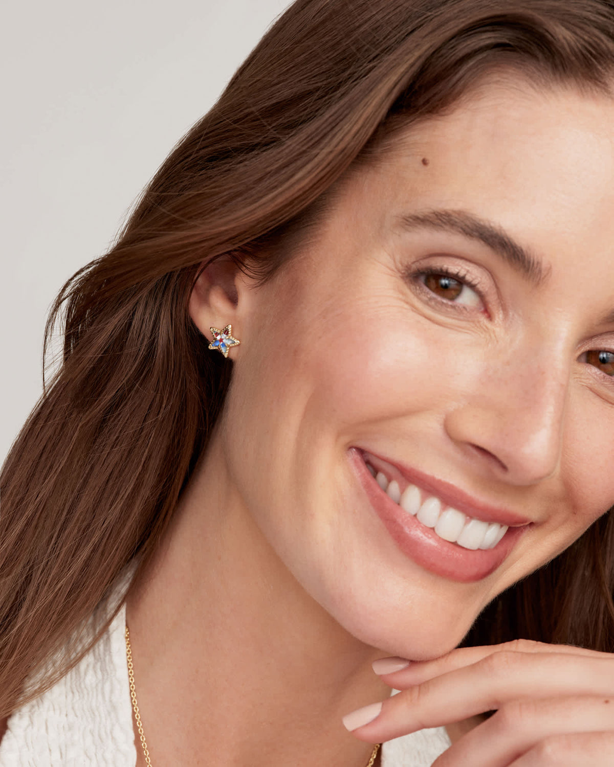 Close-up of a woman wearing the Cassidy star-shaped stud earrings with colorful stone accents.
