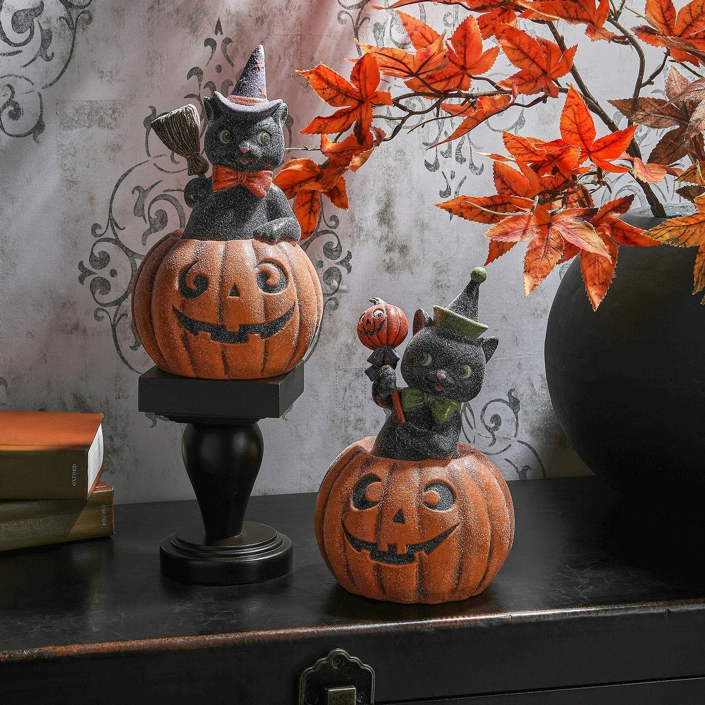 10.5-inch paper pulp black cat figurine with a sugared finish sitting inside a jack-o'-lantern.