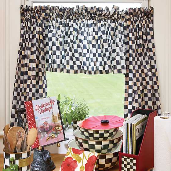 Black and white checkered cafe curtains with a ruffled top hanging over a kitchen window.