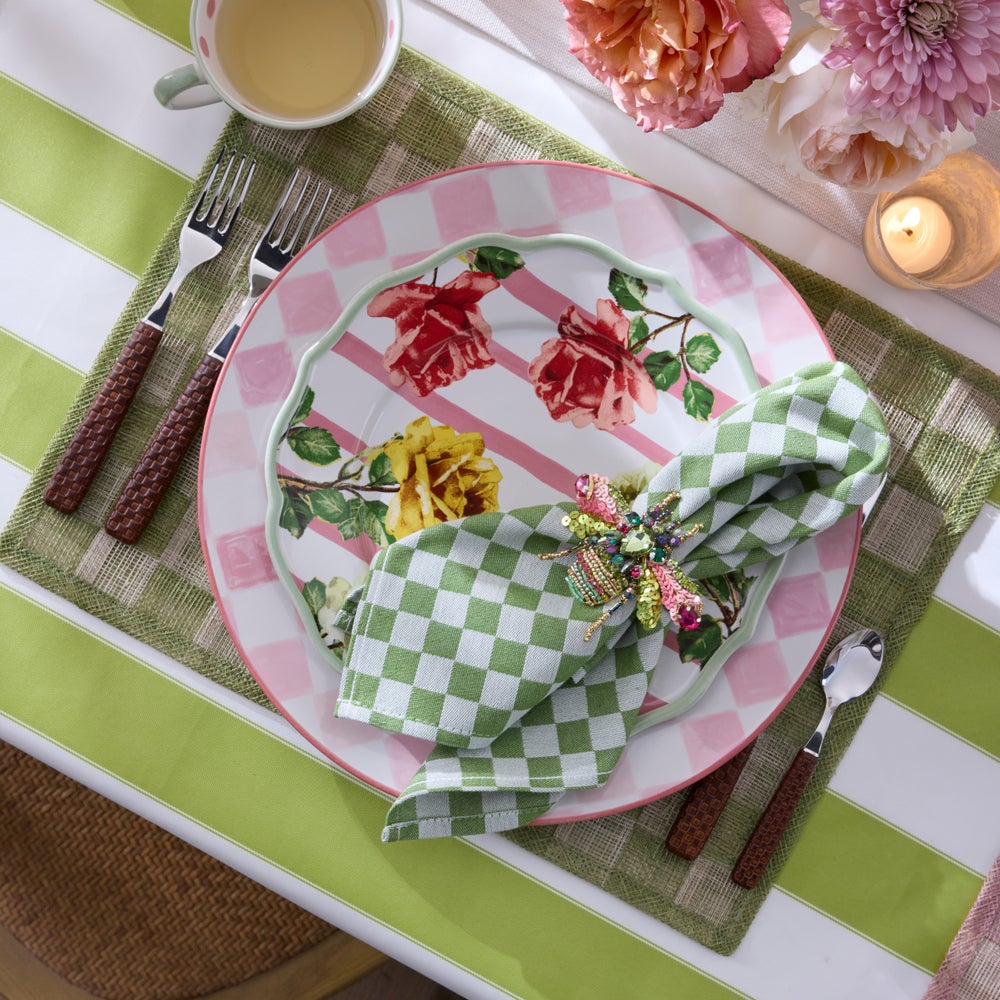 Beaded beetle napkin ring with pink and green accents on a green checkered napkin.