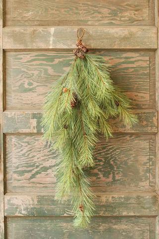 36 inch Northern Soft Pine Tear Drop with pine cones hanging on a rustic green wooden door.