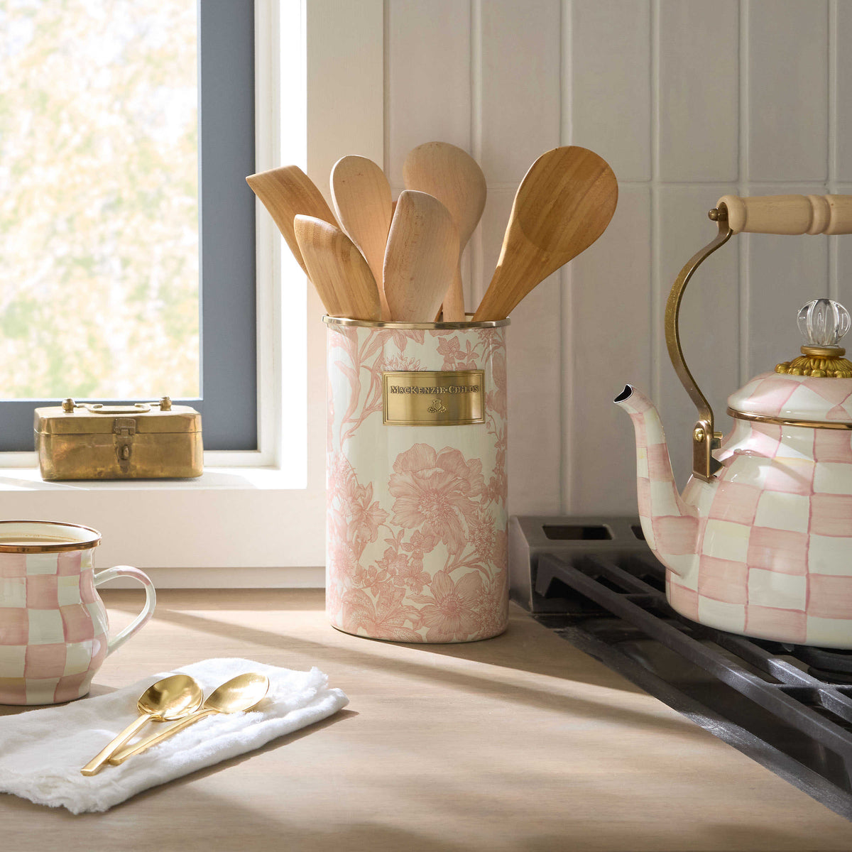 Rosy English Garden Utensil Holder with floral patterns on a kitchen counter next to a tea kettle.