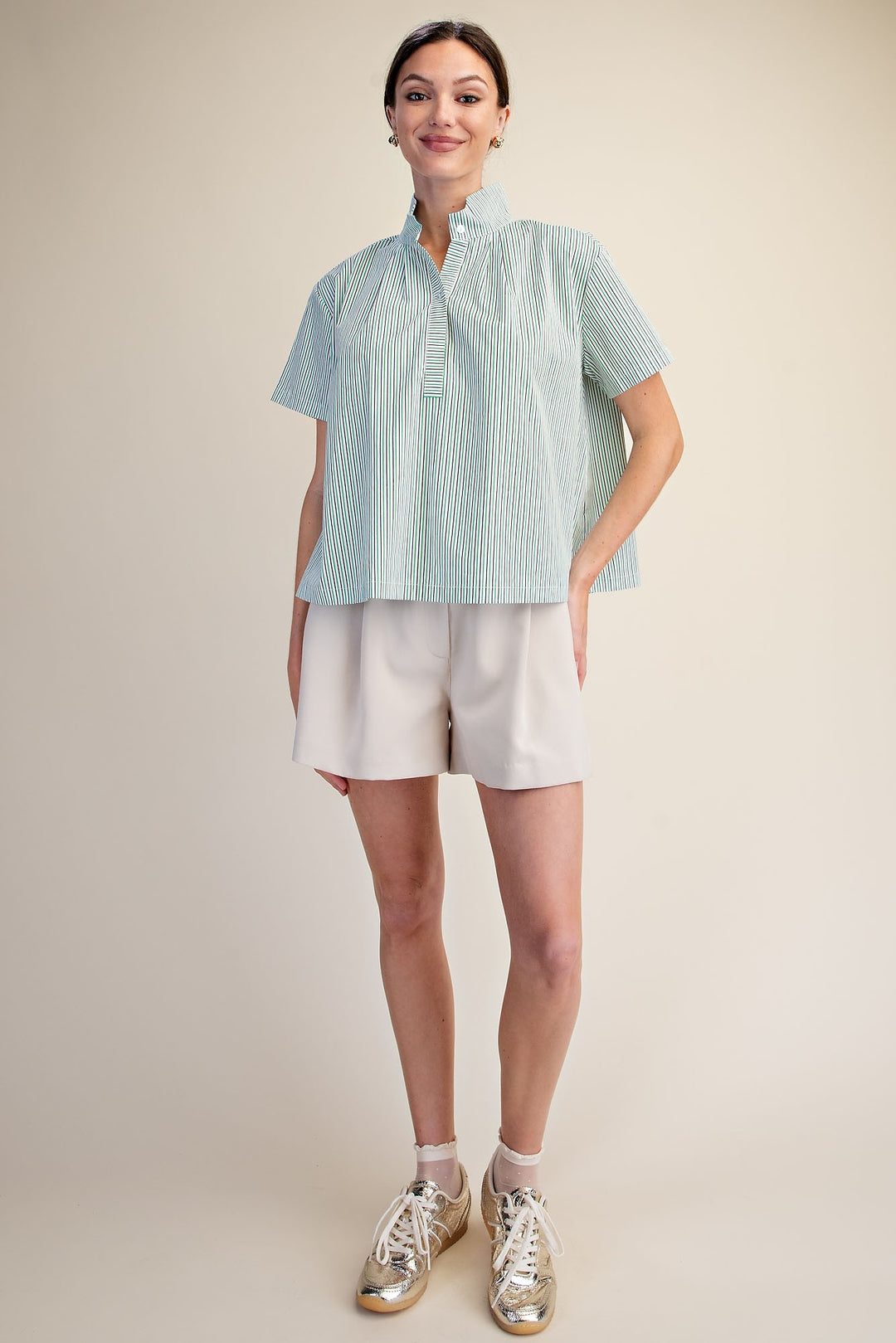 Woman wearing a green and white Sarah Stripe Shirt with a stand collar and short sleeves.
