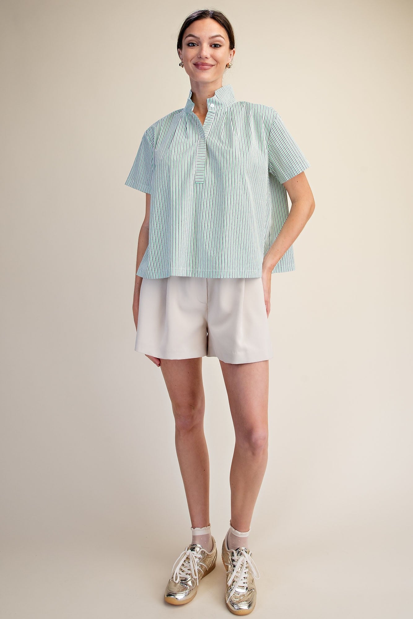 Woman wearing a green and white Sarah Stripe Shirt with a stand collar and short sleeves.