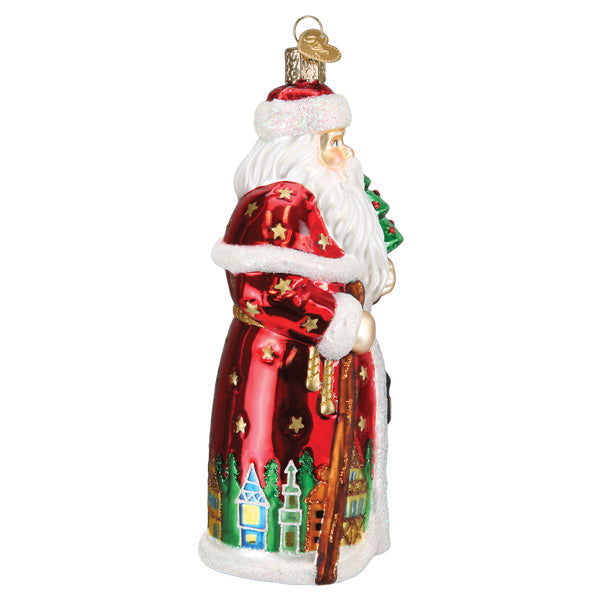 German Santa glass ornament in a red star-patterned coat with a village scene along the hem.