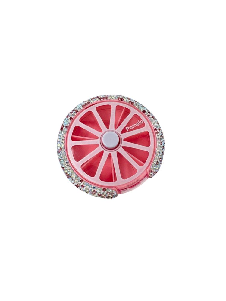 Pink circular bling pill organizer with 7 slots, a center push button, and rhinestone border.