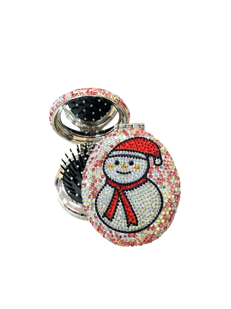 Round silver compact hair brush and mirror with a rhinestone snowman design on the lid.