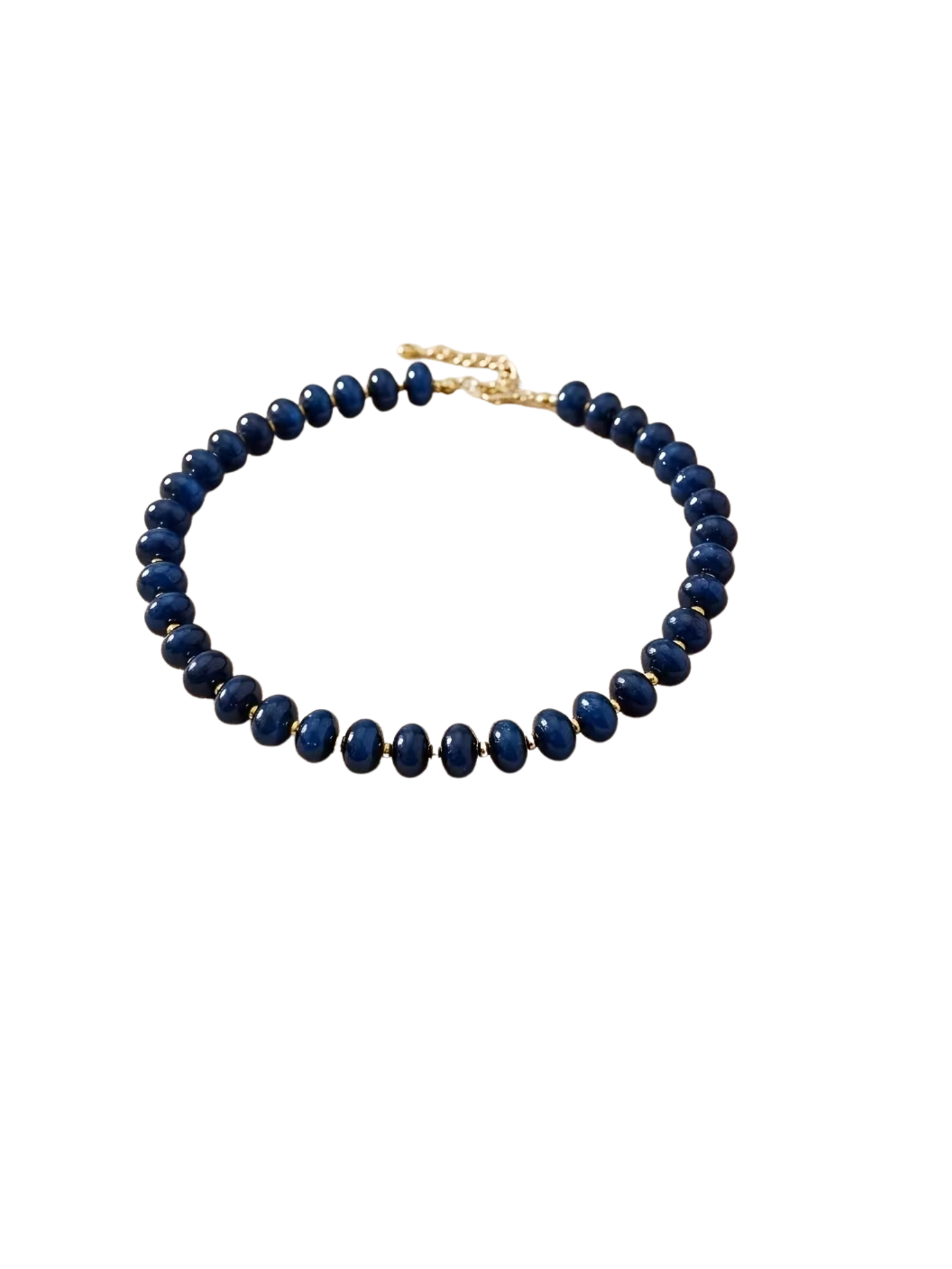 Boho beaded necklace with smooth navy blue beads and gold-tone spacers on a white background.
