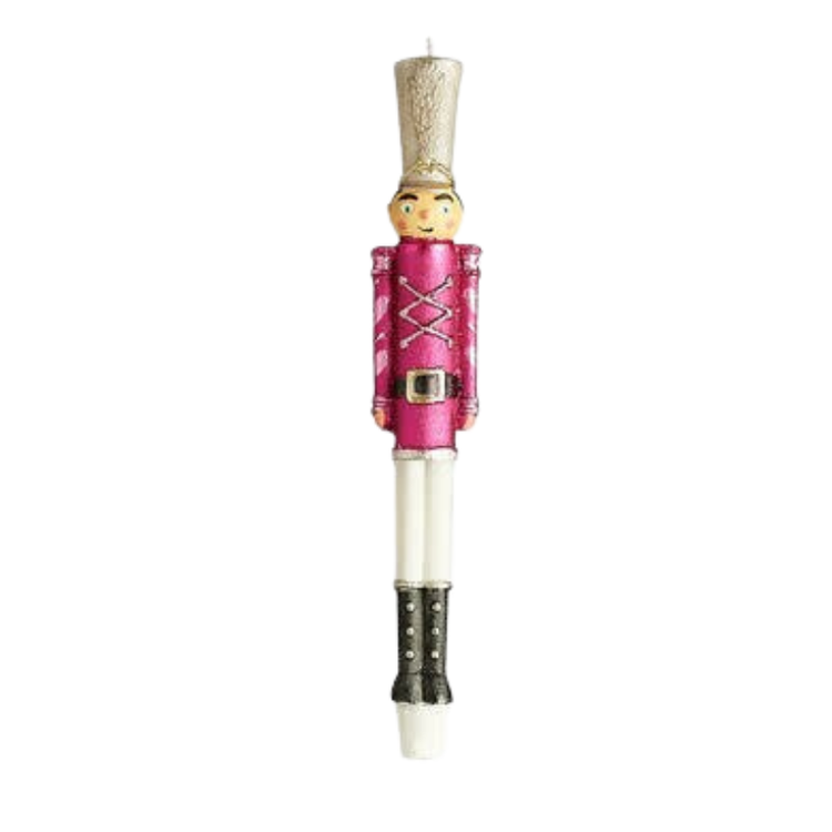 Pink nutcracker soldier taper candle with a gold hat, white pants, and black boots.