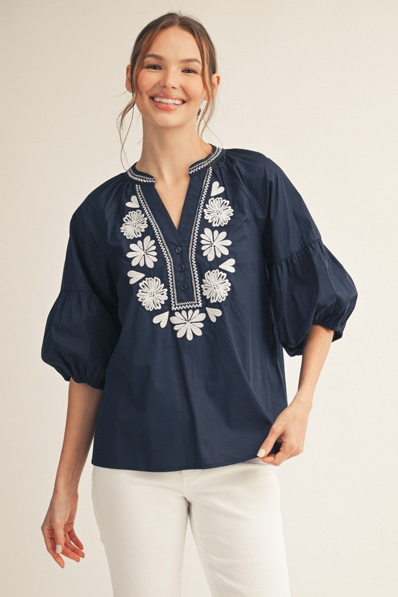 Front view of a white cotton top with balloon sleeves, notched V-neck, and front button closure.