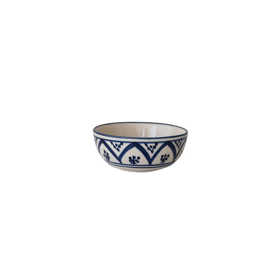 Hand-painted stoneware bowl with a blue geometric and floral pattern on a white background.