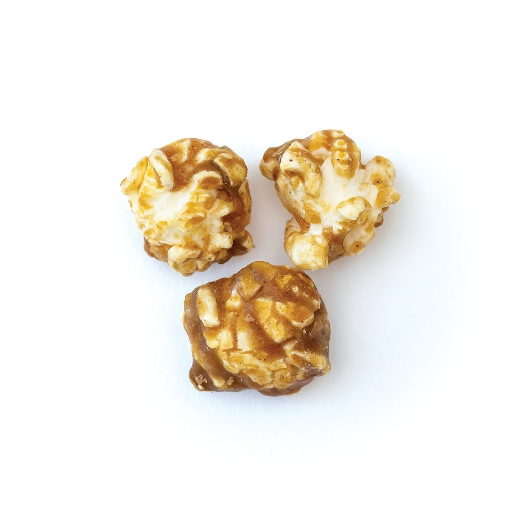 Open gift box revealing Oatmeal Cookie Popcorn with brown sugar coating inside