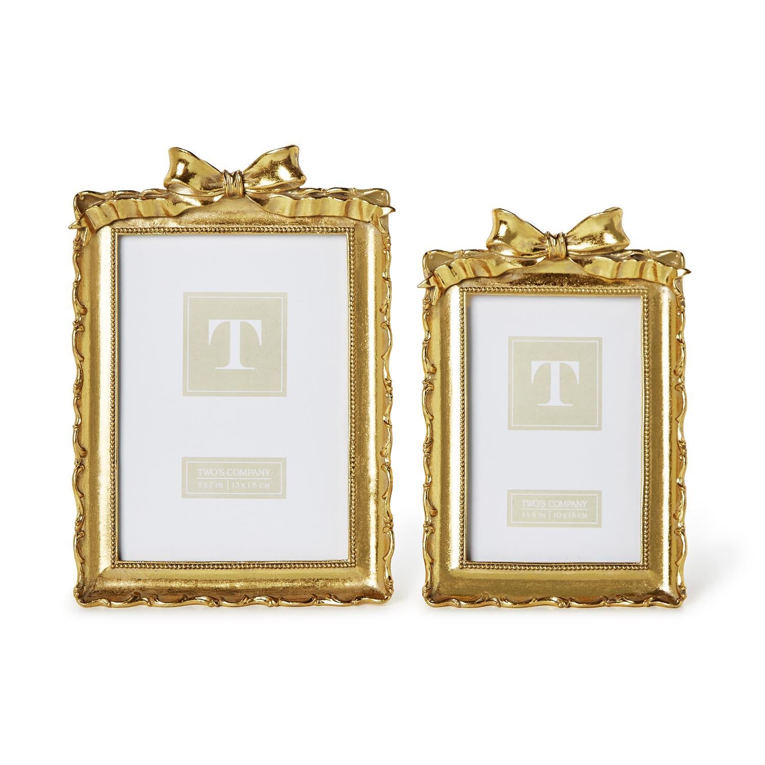 Two vintage-style gold resin picture frames with ornate borders and decorative bows on top.