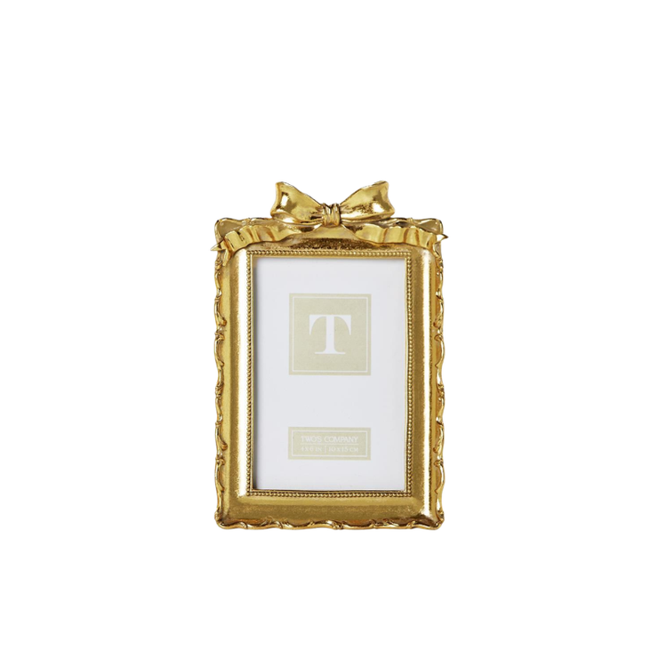 Vintage gold resin picture frame with an ornate scalloped edge and a decorative bow on top.