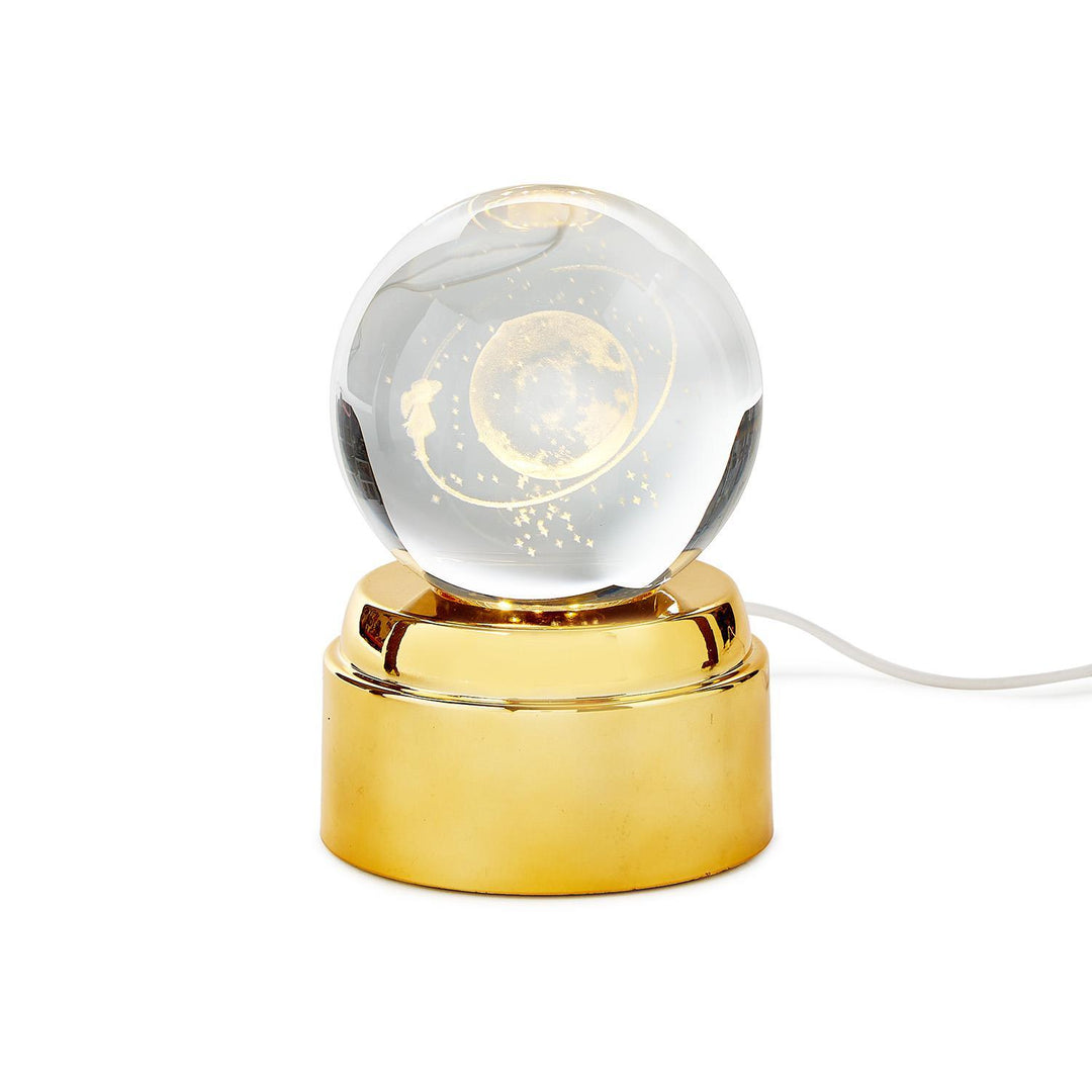 Rotating crystal ball nightlight with a moon and stars design on a gold base with a USB cord.