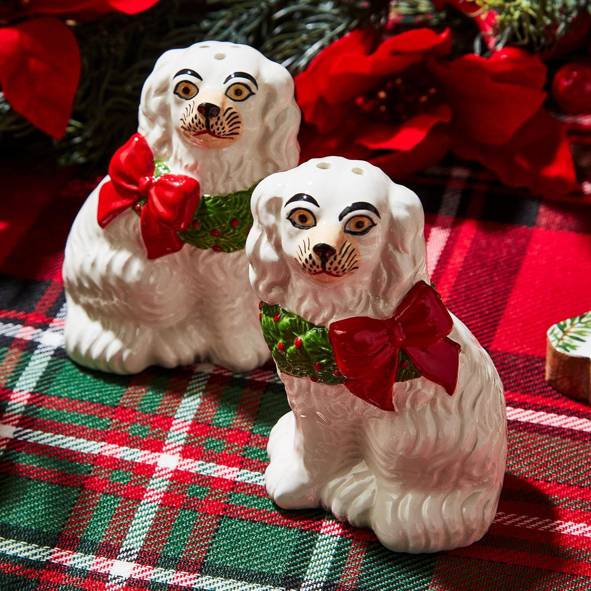 Ceramic salt and pepper shakers featuring a black Staffordshire dog holding a green wreath.