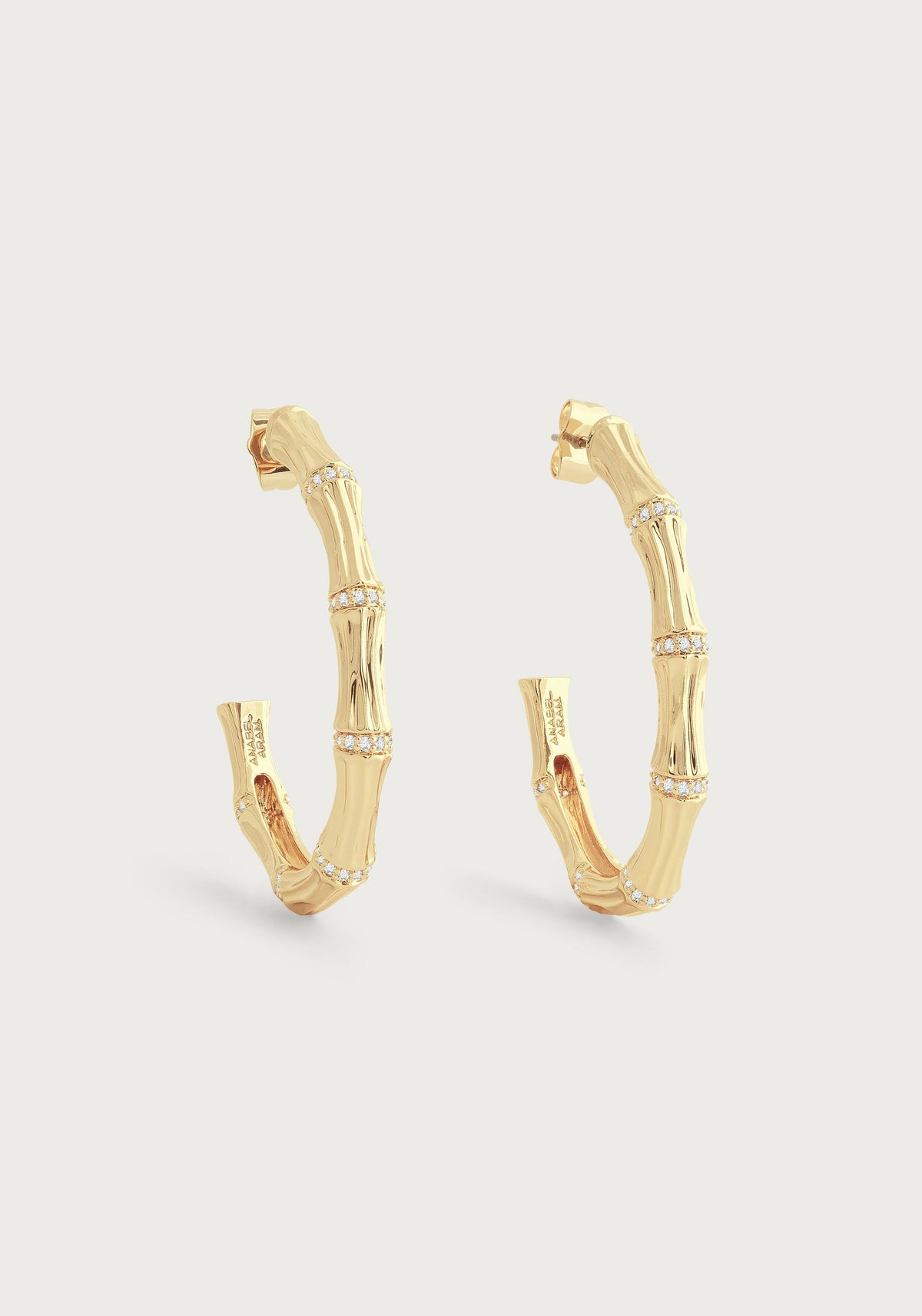 Gold-plated bamboo-shaped hoop earrings with crystal pavé accents.