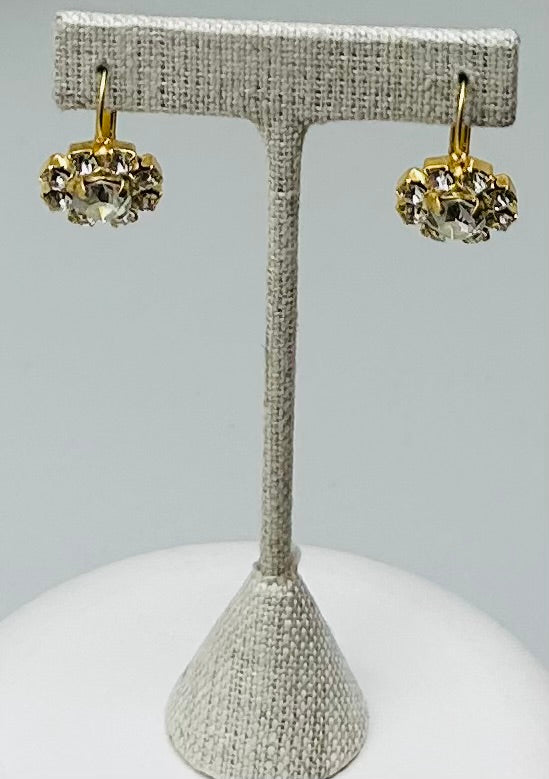 Gold round stud earrings featuring a central stone with pave setting.