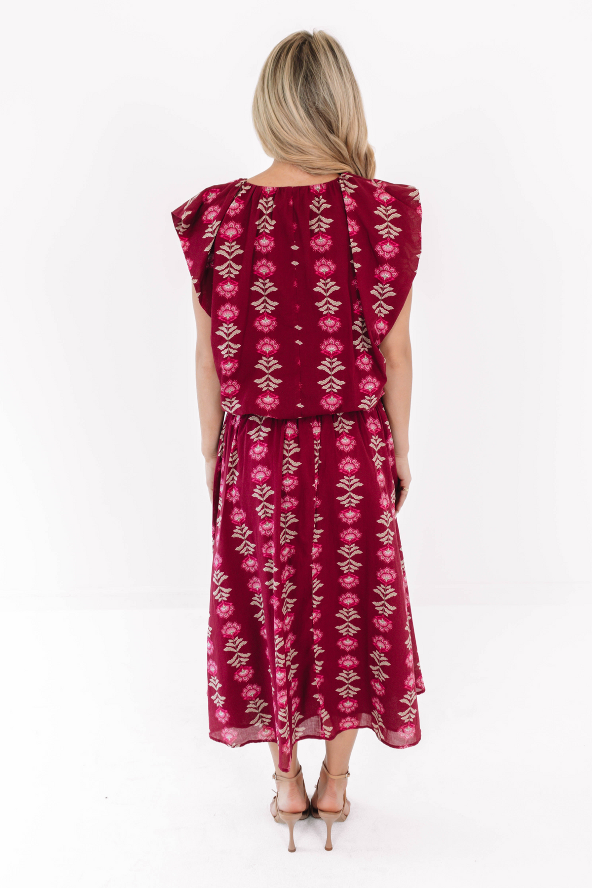 Back view of a woman wearing the wine-colored Jane The Bubble Top with a floral print.