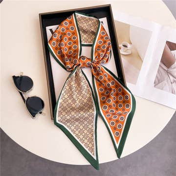 Double-layer head scarf with orange and beige geometric patterns and a green border.