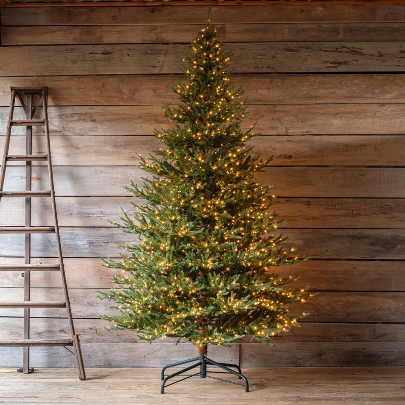 9-foot Olympia Fir artificial Christmas tree with warm white LED lights on a metal stand.