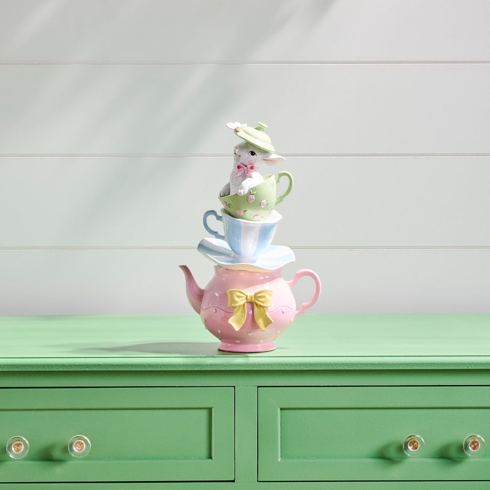 Stacked resin tea cups in cream with a white bunny figurine on top.