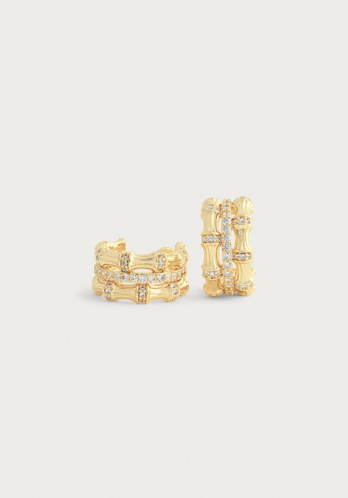 Gold-plated bamboo-style stacked hoop earrings with crystal pavé accents on a white background.
