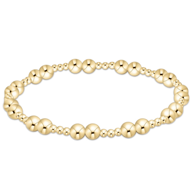 Gold beaded Together Bracelet with alternating large and small spheres on an elastic cord.