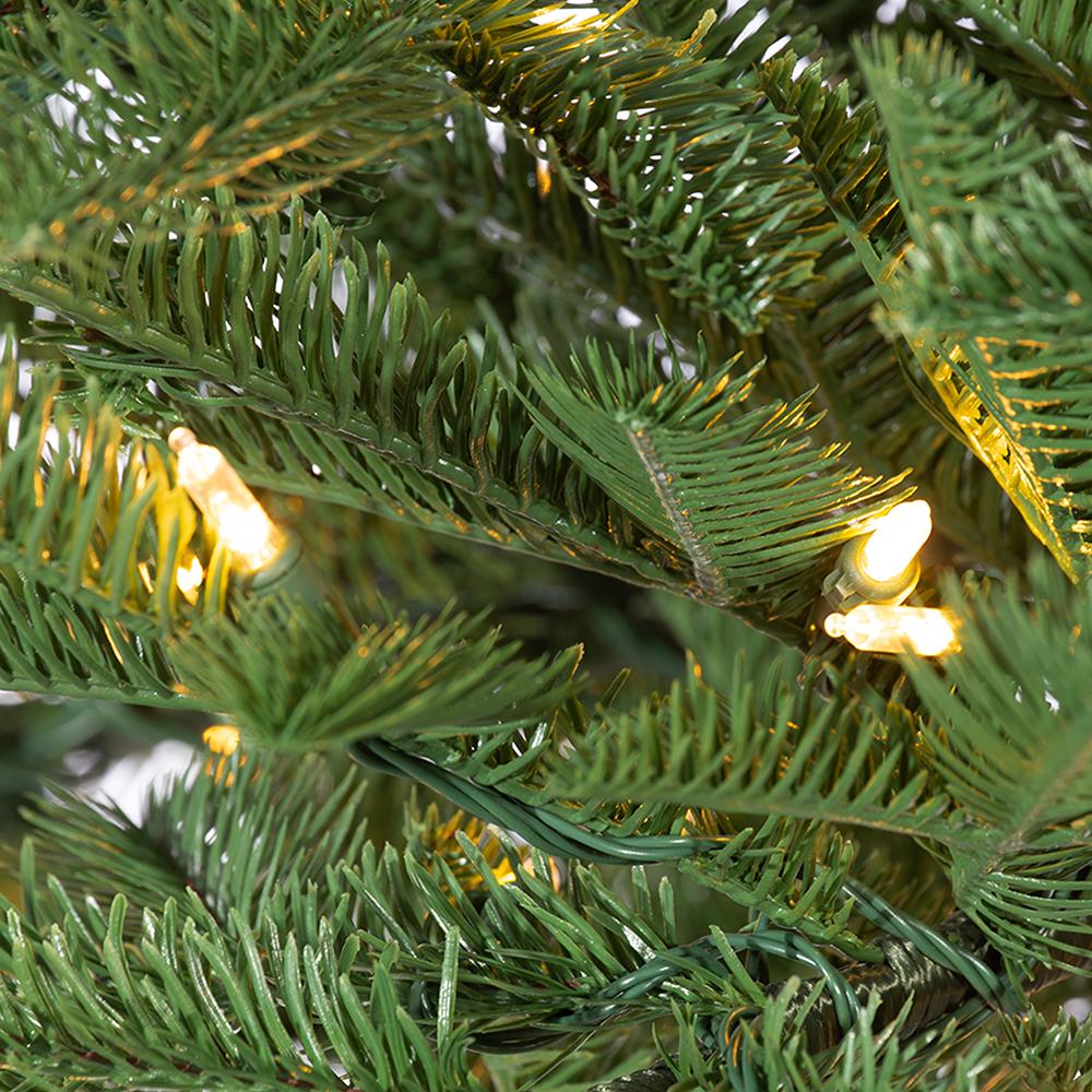 Close-up of green pencil pine tree needles with glowing warm white LED lights.