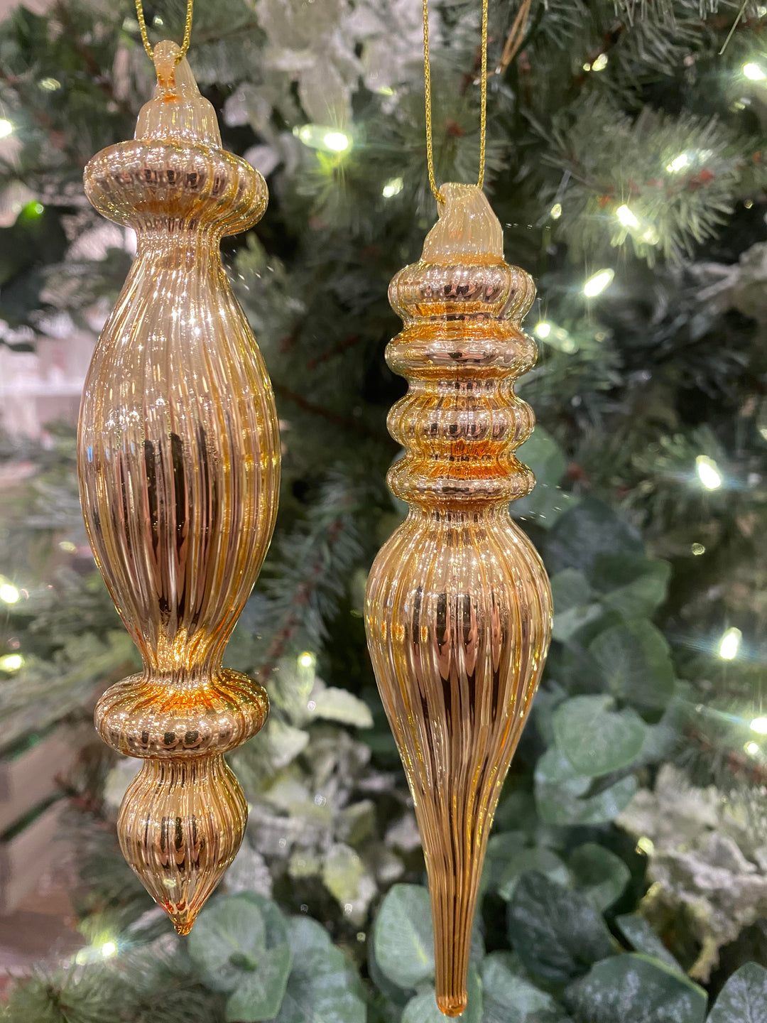 Gold metal finial ornament with a classic tapered cone shape.