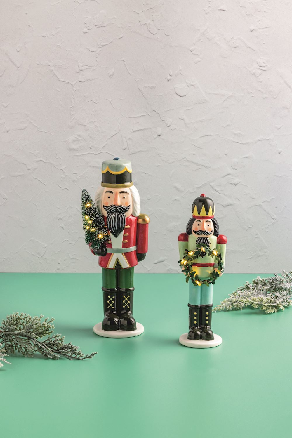 Ceramic LED nutcracker sitter with a festive red hat, gold accents, and built-in battery-operated lighting.