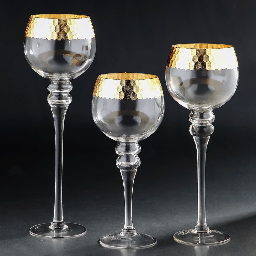 Set of three hurricane glass candle holders in varying heights with gold honeycomb rims.