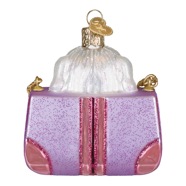 Posh Pup ornament in faux fur peeking from a designer bag with holiday sparkle