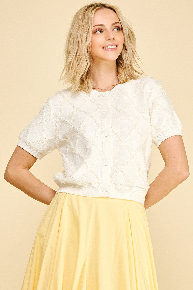 Front view of an Amelia textured diamond pattern knit cardigan in natural cotton with a relaxed silhouette.