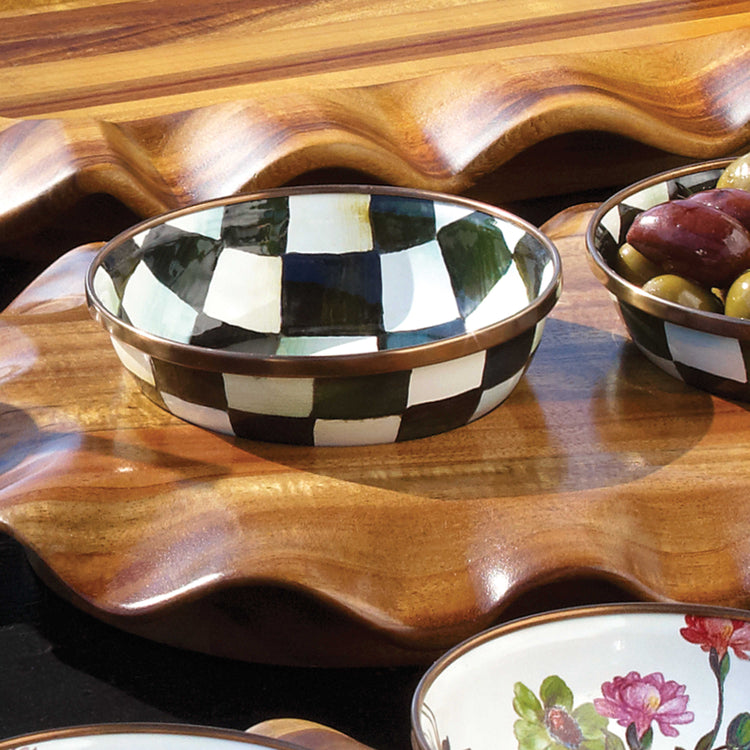 Hand-painted Courtly Check relish dish with a bronzed stainless steel rim on a wooden tray.