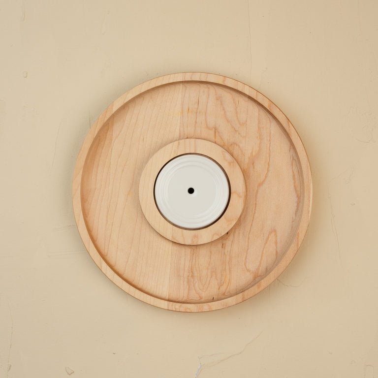 Top view of an 8-inch round maple wood cracker board with a white ceramic center insert.