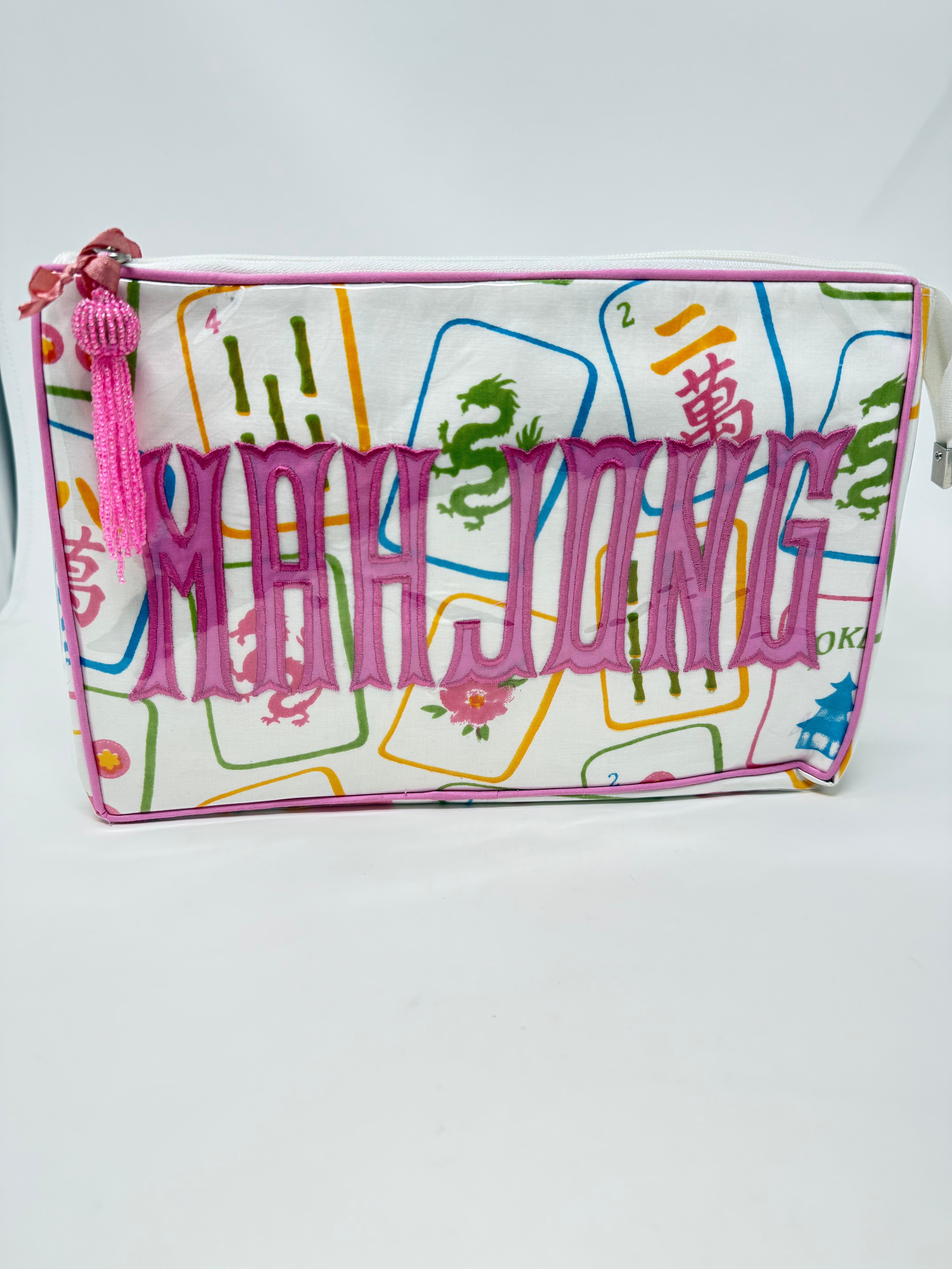 Tiana cosmetic bag with a mahjong tile print, pink trim, and large pink 'MAH JONG' lettering.