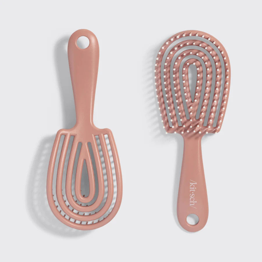 Mini terracotta-colored flexible detangling brush with bendable bristles in recycled plastic.